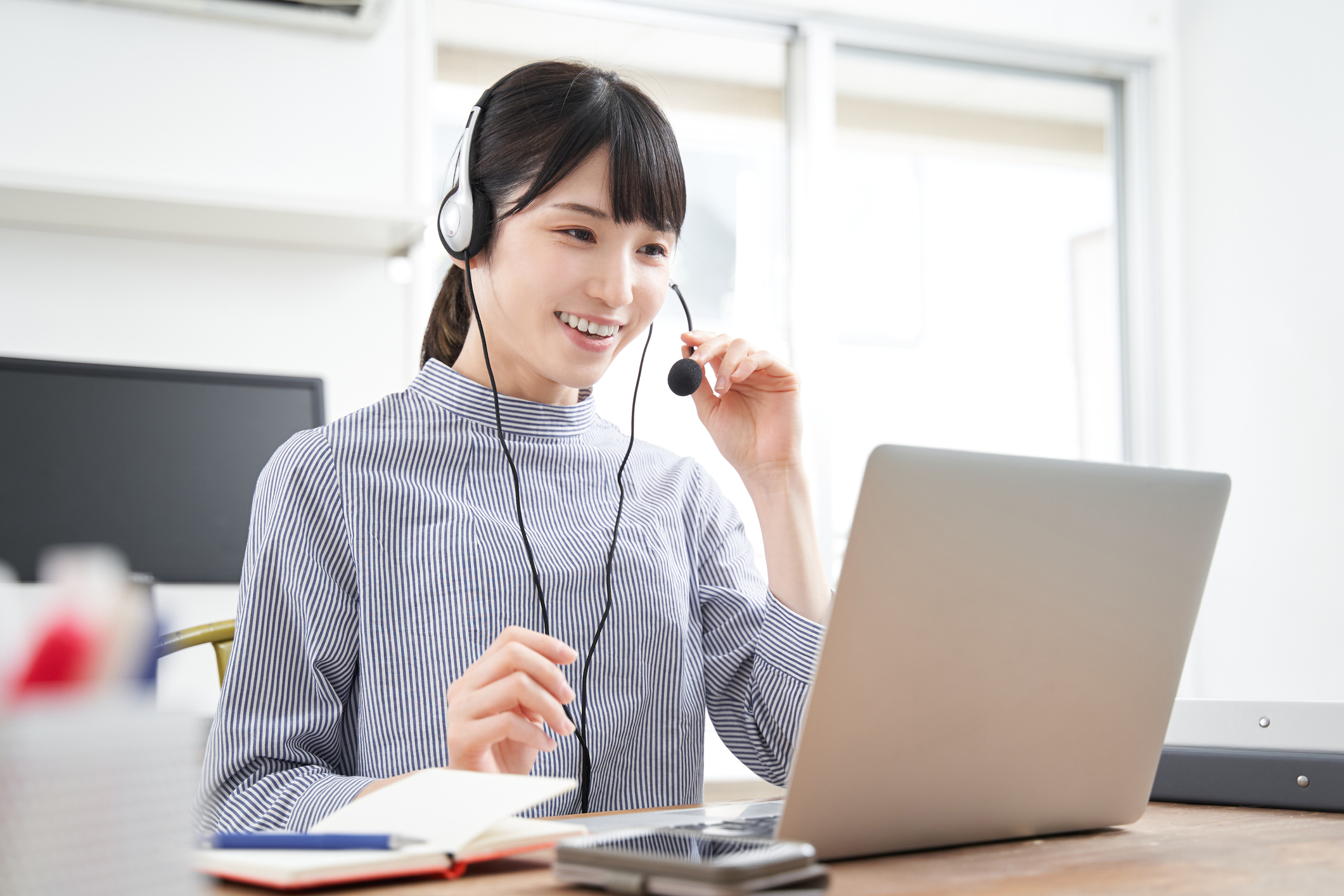 A plainclothes Japanese businesswoman in an online meeting at home
